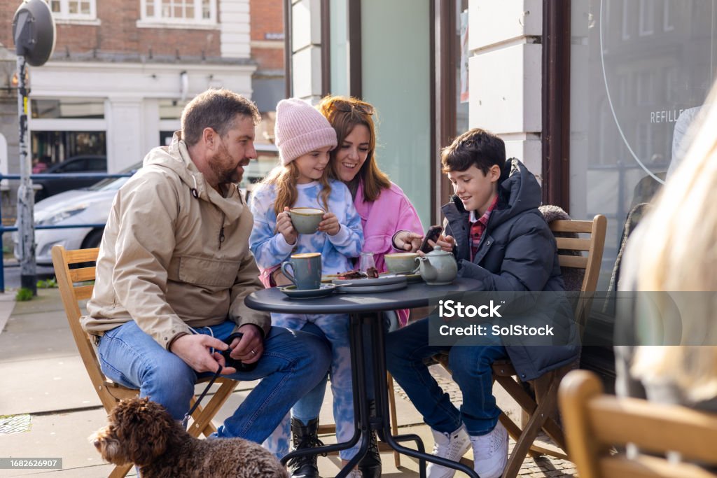 A cheerful family enjoying drinks and conversation at a café.
